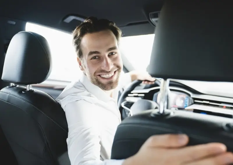 un chauffeur de taxi qui regarde en arriere en souriant